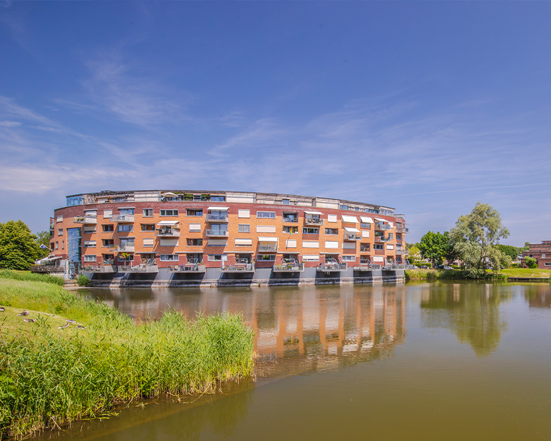 Modern appartementencomplex gelegen aan het water met balkons en groen