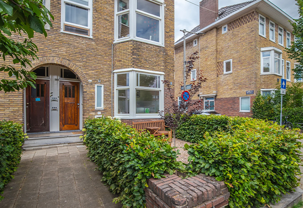 Bakstenen woning met erker, authentieke voordeur en groene voortuin