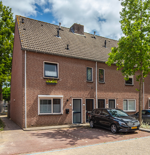 Bakstenen rijtjeswoningen met parkeergelegenheid in een groene woonwijk